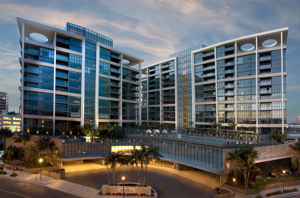 A modern building with glass windows and a bridge connecting two towers.