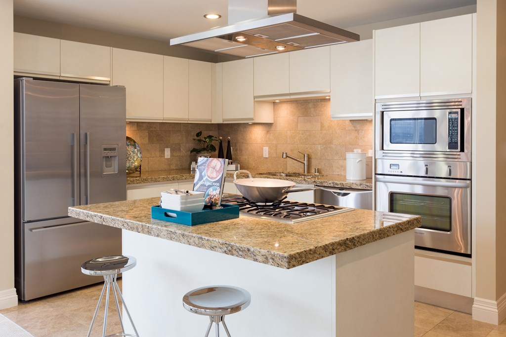 A kitchen with a granite countertop and stainless steel appliances.