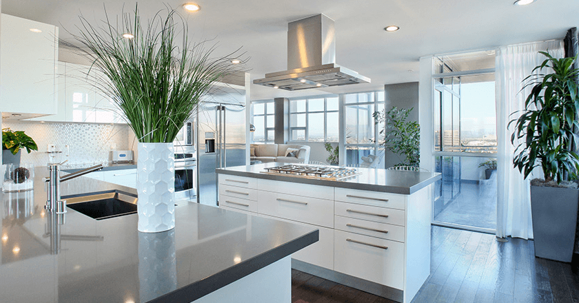 A modern kitchen with a large island and a view of the outdoors.