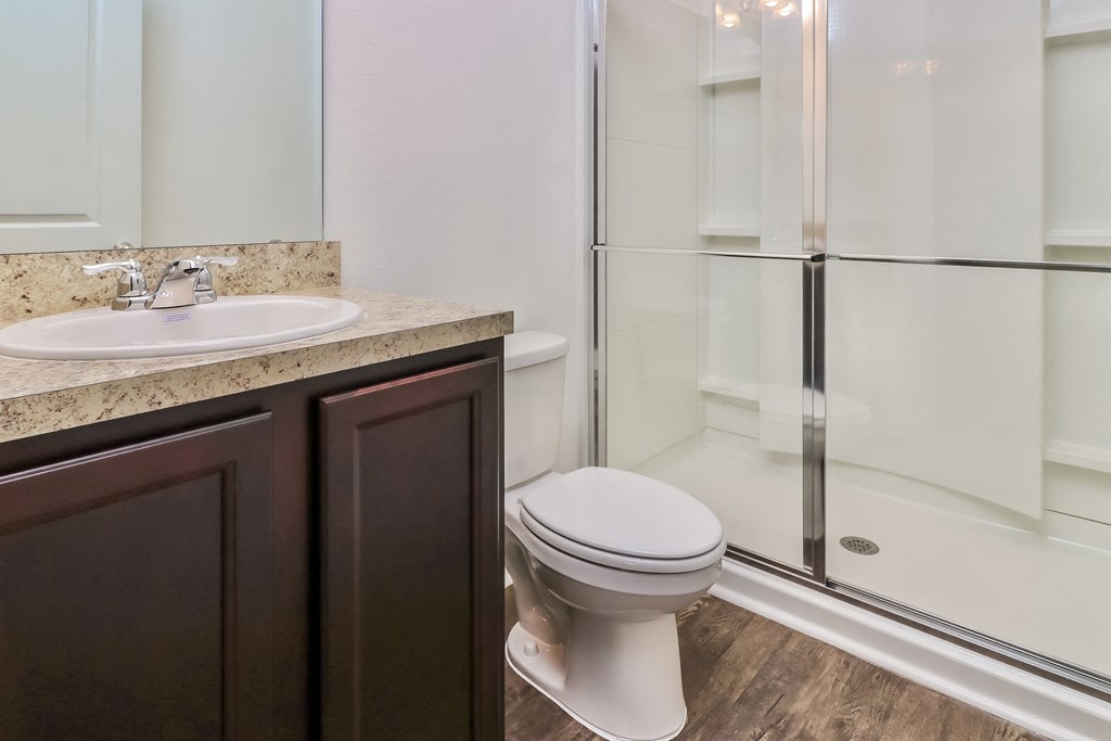 A white toilet sits next to a sink in a bathroom.