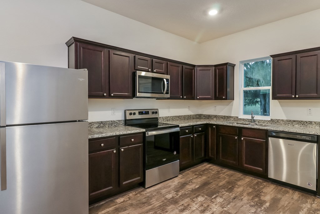 A kitchen with brown cabinets and stainless steel appliances.
