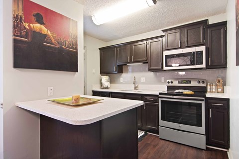full kitchen with black cabinets and white countertops and stainless steel appliances