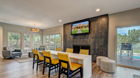 A modern living room with a television and yellow chairs.