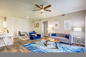 Henderson Apartments - Spacious Living Room with Stylish Interior Featuring Hardwood Floors and a Large Window