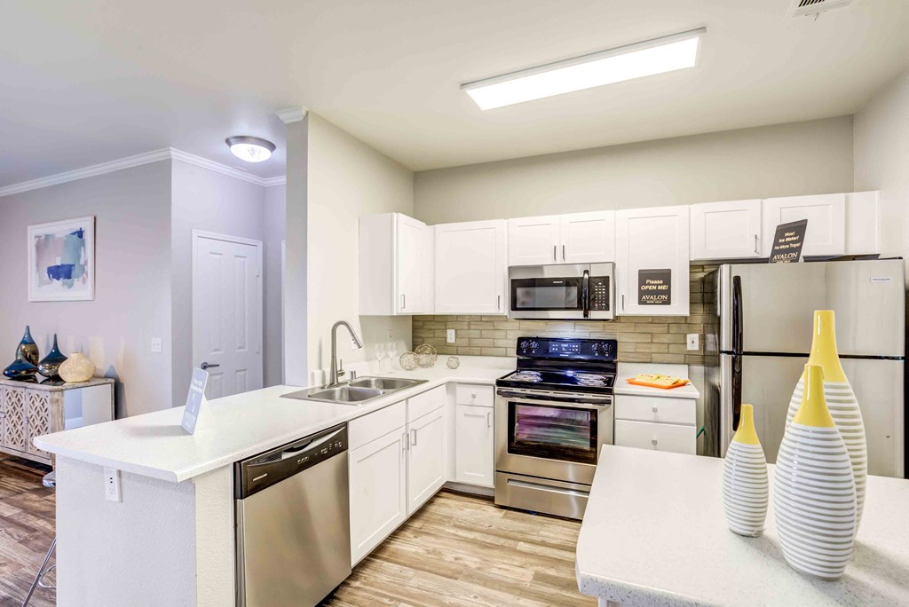 Henderson Apartments for Rent-Avalon at Seven Hills Kitchen with Modern Lighting, Matching Stainless Steel Appliances, and Stylish Tile-Backsplash