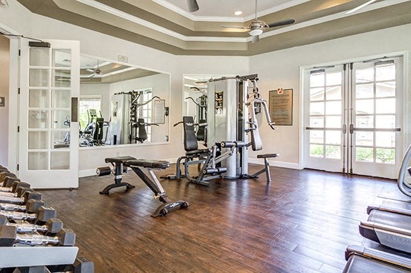 the fitness room has plenty of exercise equipment and windows