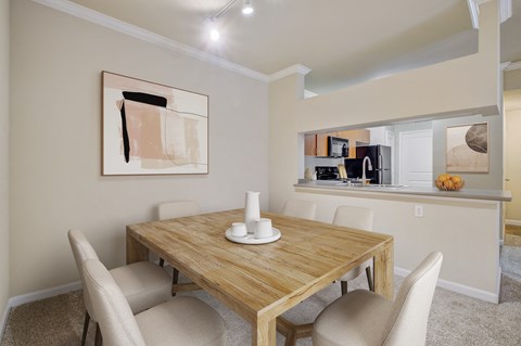2 Bedroom Apartments in North Sacramento, CA - Avanti - Dining Area with Carpet Flooring, Table, Chairs, 9-foot Ceiling, Track Lighting, and View of Kitchen.