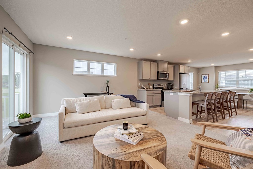 a living room and kitchen with a couch and a table