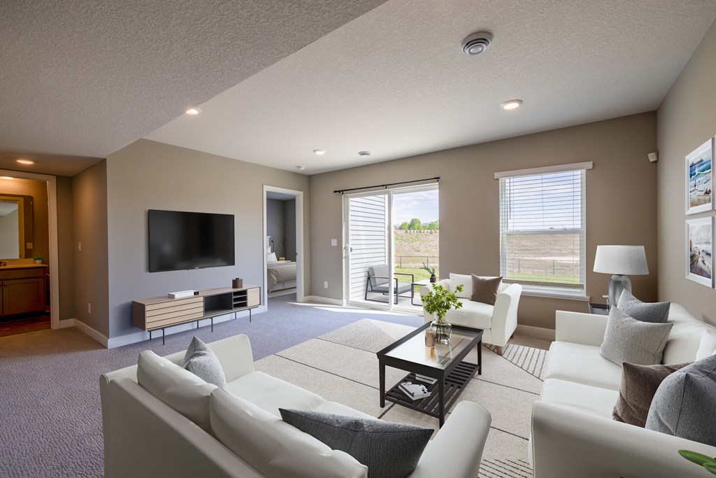 A living room with a white couch and a television.