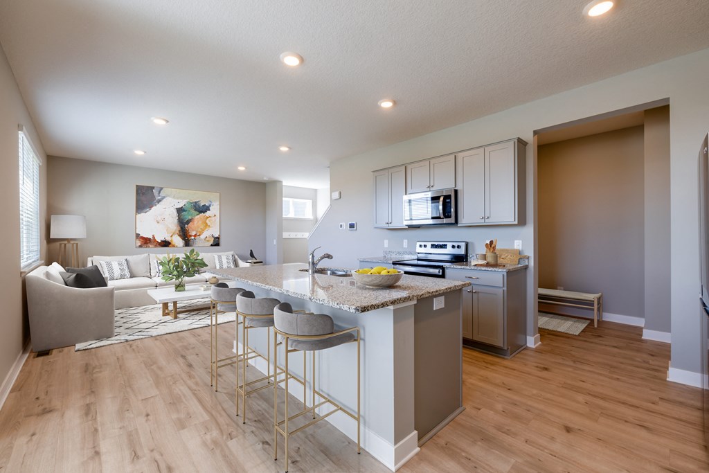 an open kitchen and living room with a marble counter top