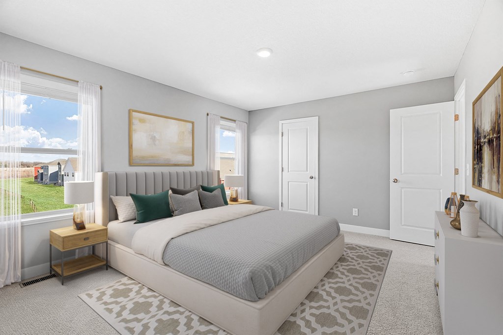 A bedroom with a large bed and a painting on the wall.