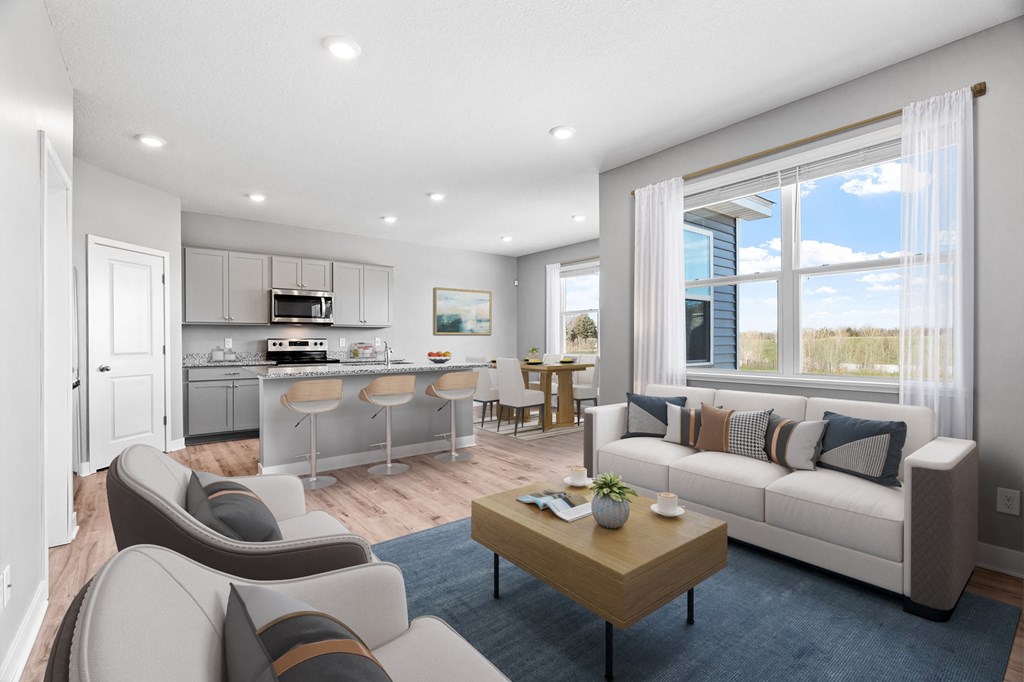 A modern living room with a kitchen area in the background.