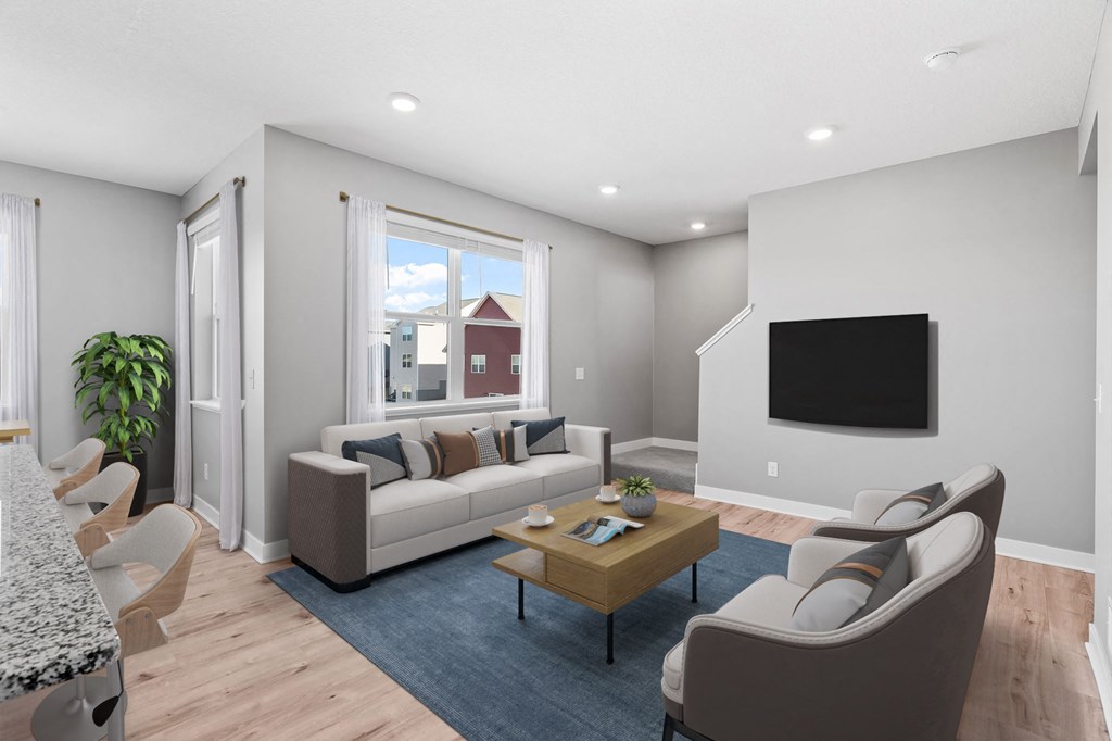 A modern living room with a sofa, chairs, and a television.