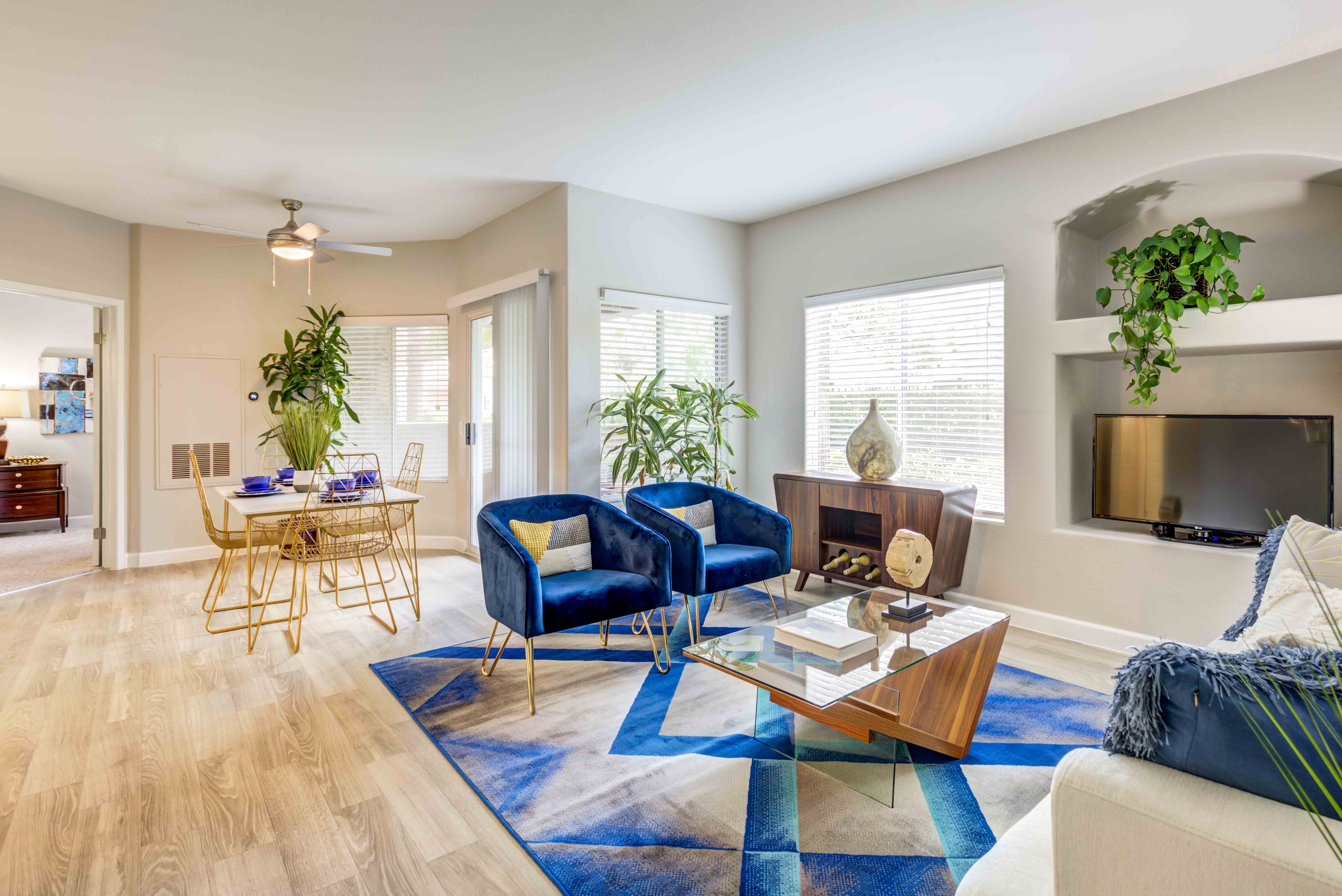 a living room with blue chairs and a fireplace