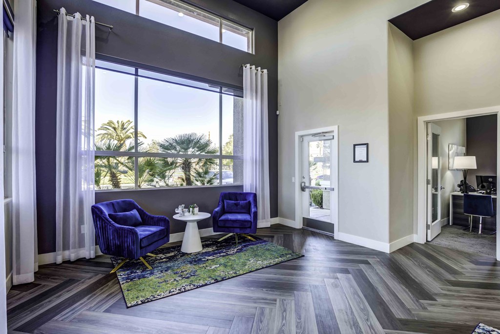a living room with a large window and two blue chairs