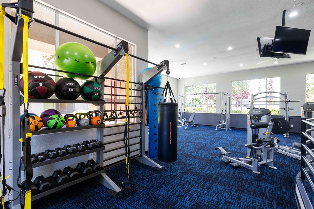 a gym with weights and cardio equipment in a room with a window