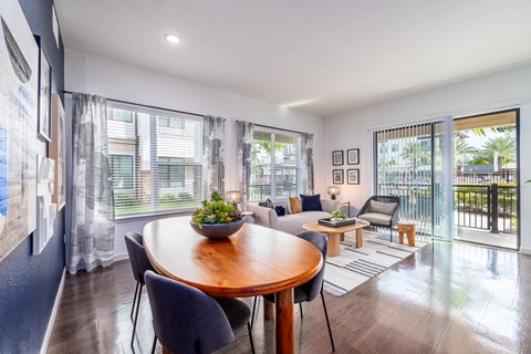 a living room with a dining room table and a balcony
