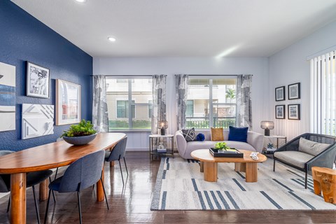A modern living room with a dining table and grey chairs.