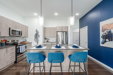 A kitchen with a table and chairs.