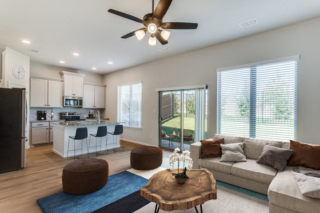 A modern living room with a kitchen in the background.