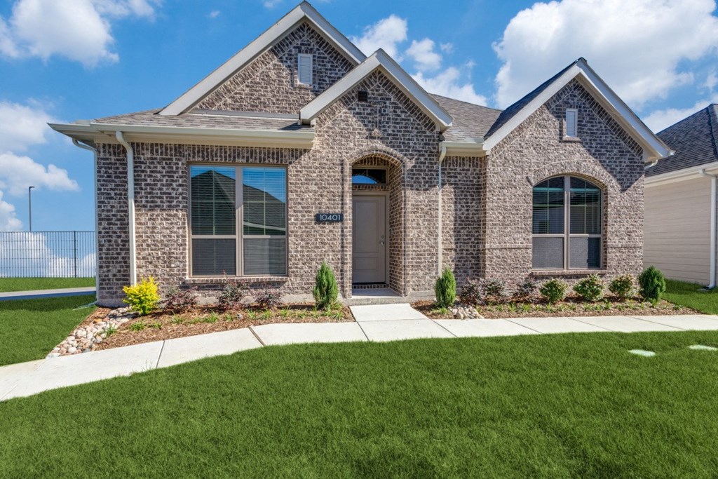a house with a lawn and a sidewalk in front of it