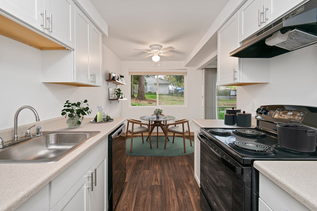 a kitchen with white cabinets and a dining room with a table