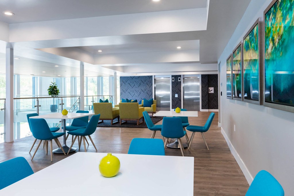 a dining room with blue chairs and white tables and chairs