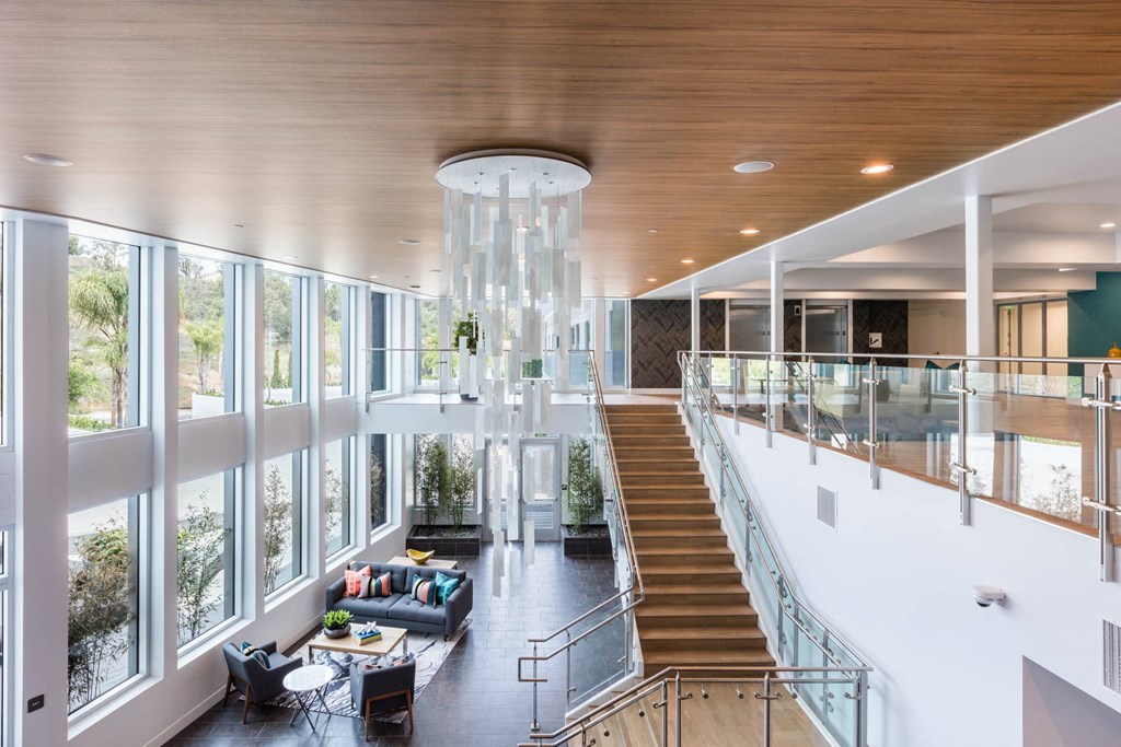 the lobby of a building with a staircase and a large amount of windows