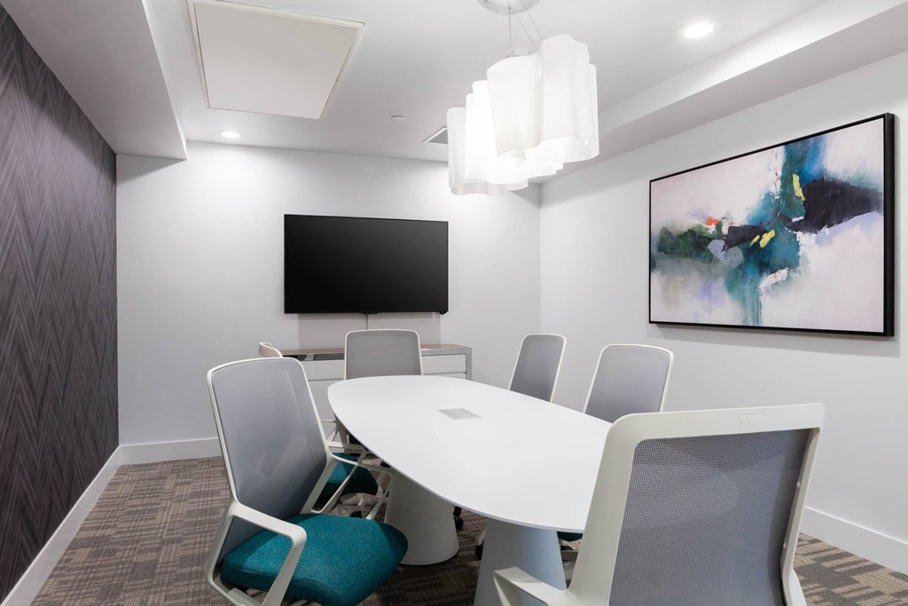 a conference room with a table and chairs and a tv