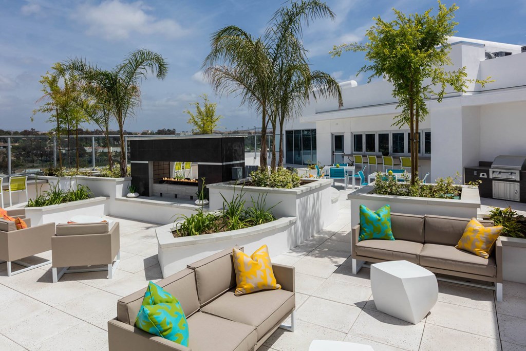 a patio with couches and chairs and palm trees