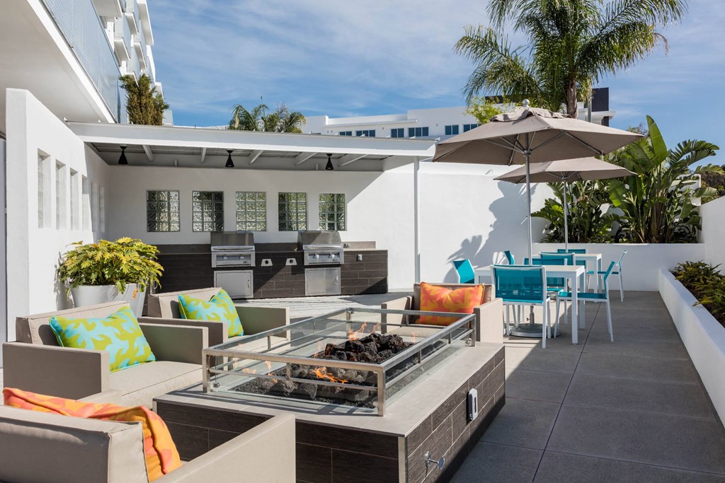 a patio with tables and chairs and a fire pit