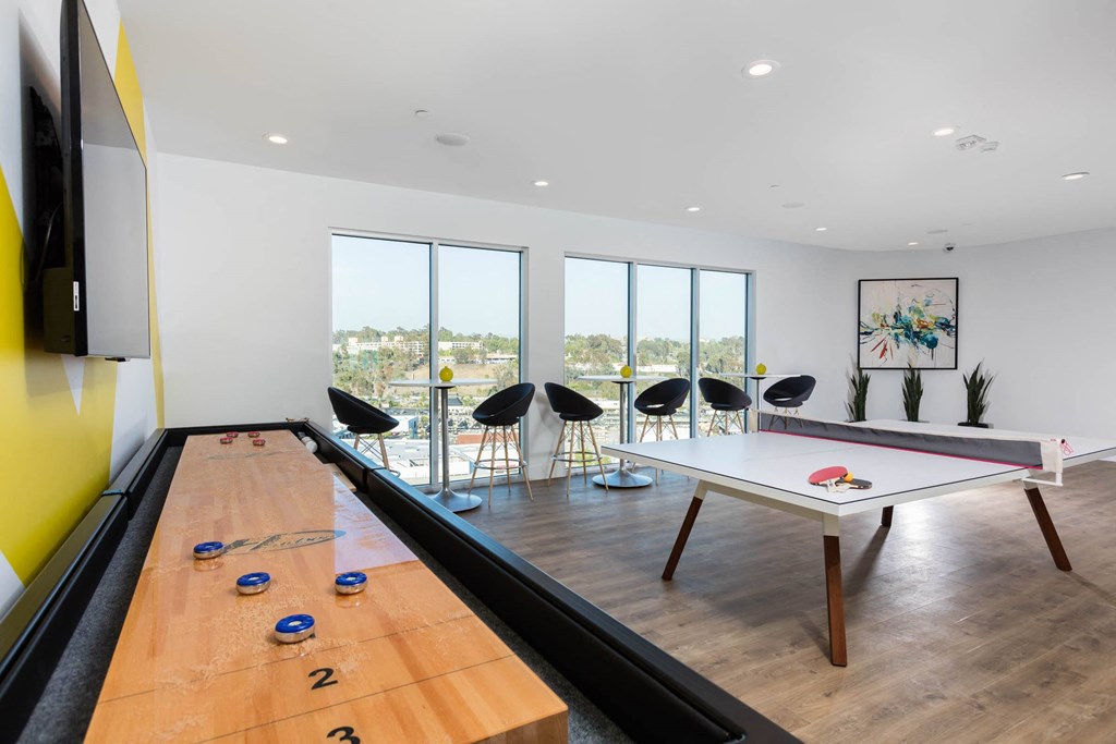 a games room with a ping pong table and a view of the city