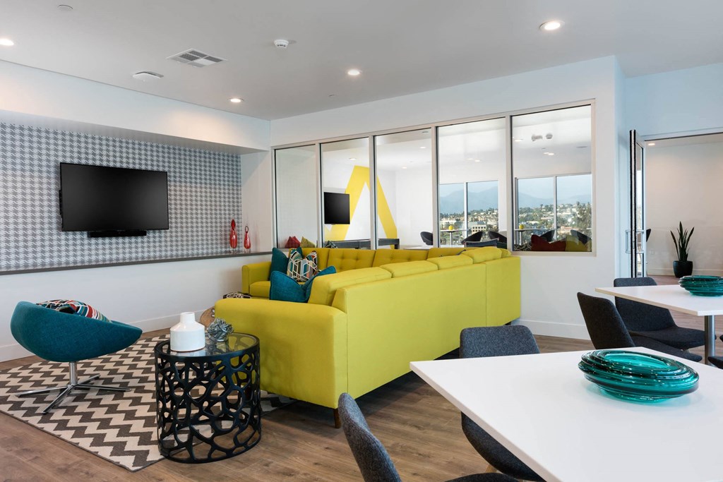 a living room with a yellow couch and a table