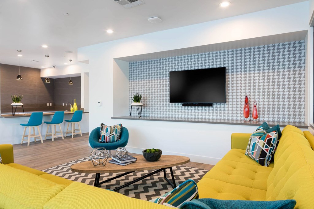 a living room with a yellow couch and a television