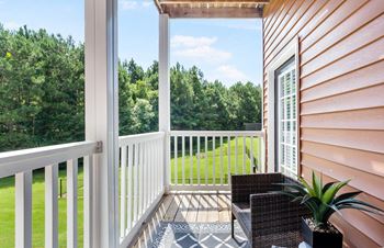 a balcony with a view of a yard and trees