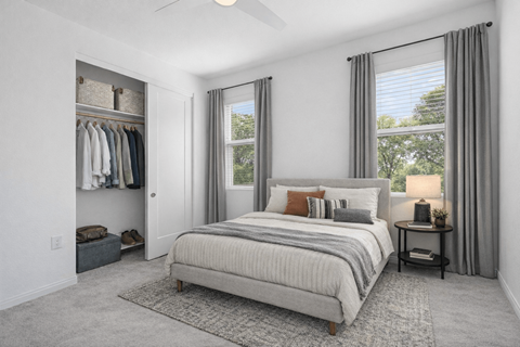 A bedroom with a large bed and a window with curtains.