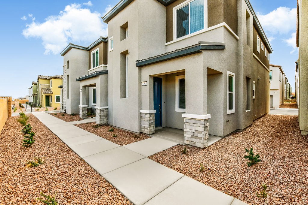 a street view of a house with a sidewalk and landscaping