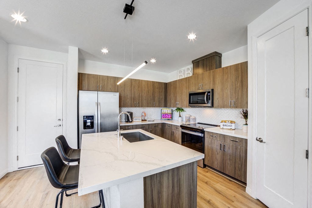 a kitchen with a white counter top and wooden cabinets