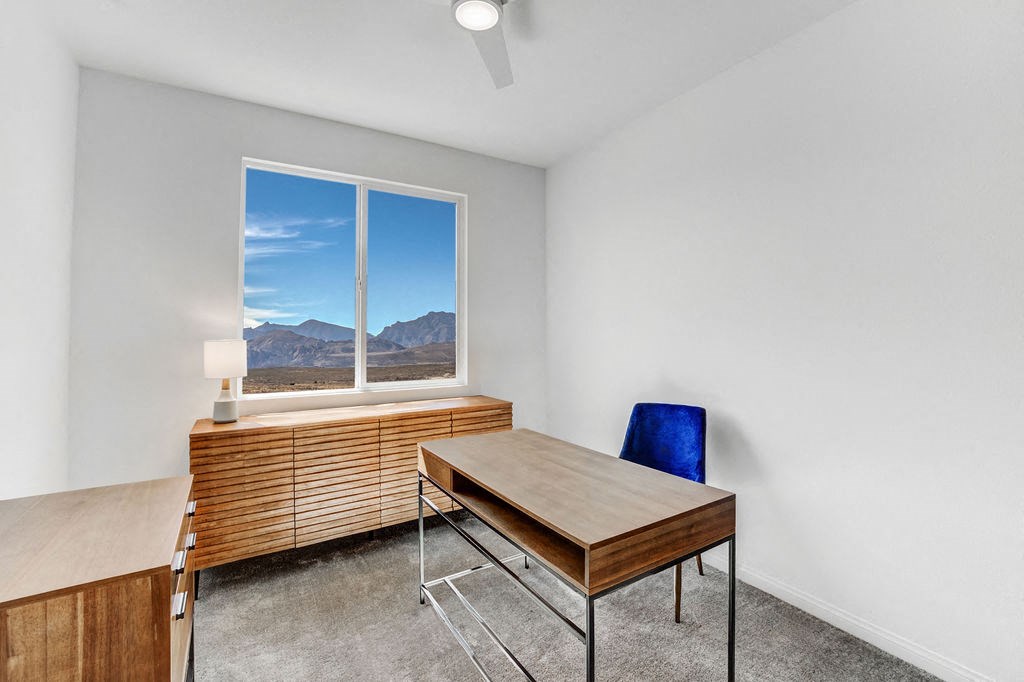 a office with a desk and a window with mountains