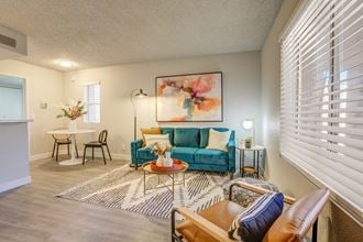 Dog Friendly Apartments in Phoenix, AZ - Adrella on 28th - Living Room with Wood-Style Flooring, Large Windows, and Stylish Decor