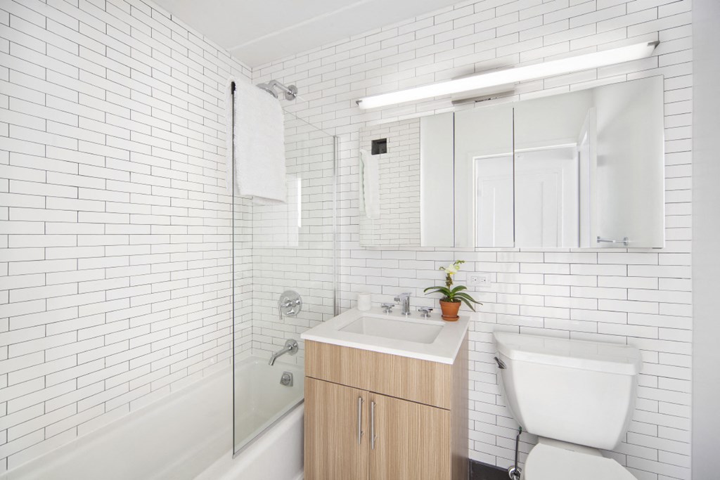a white bathroom with a toilet sink and shower