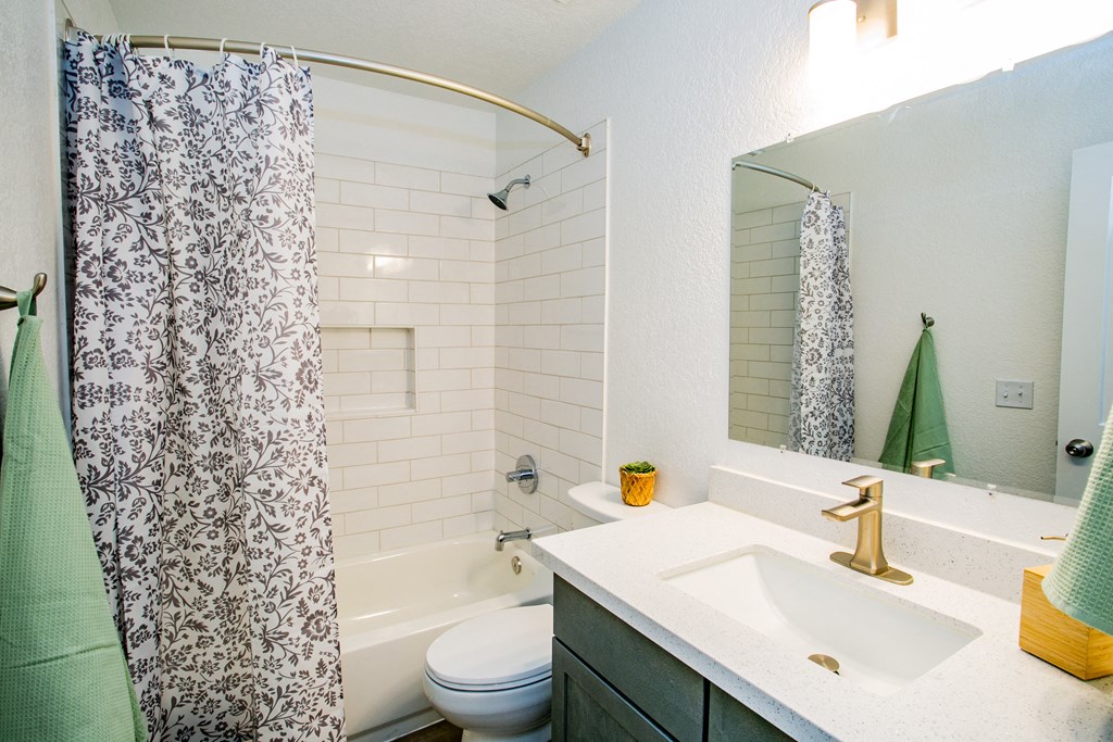 a bathroom with a shower curtain and a sink and a toilet