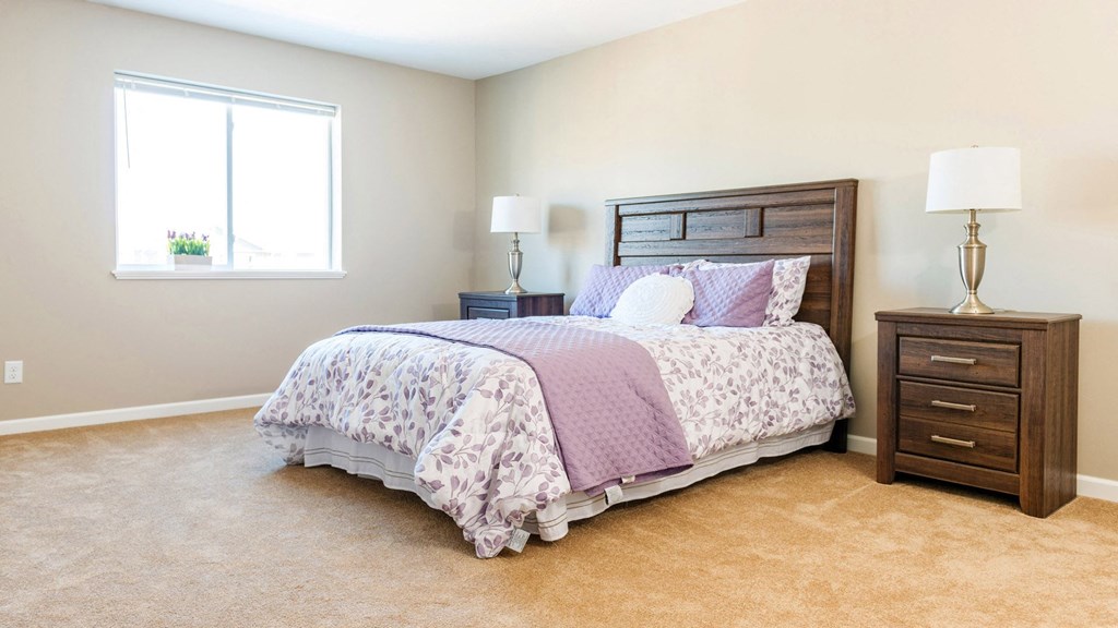 a bedroom with a bed and a dresser and a window