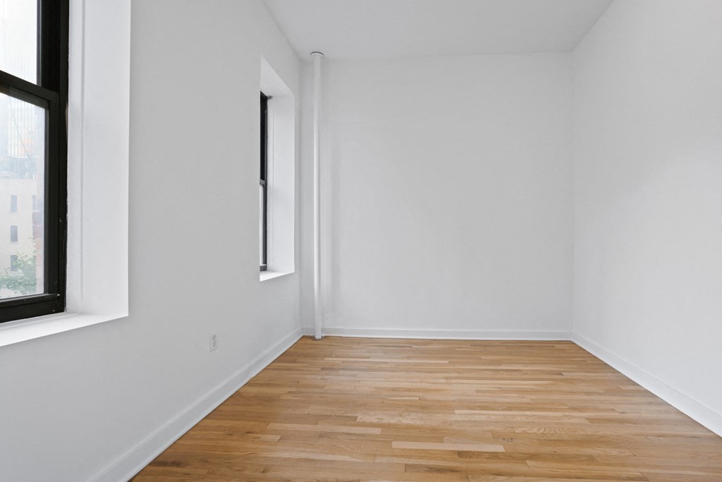 an empty room with white walls and a window