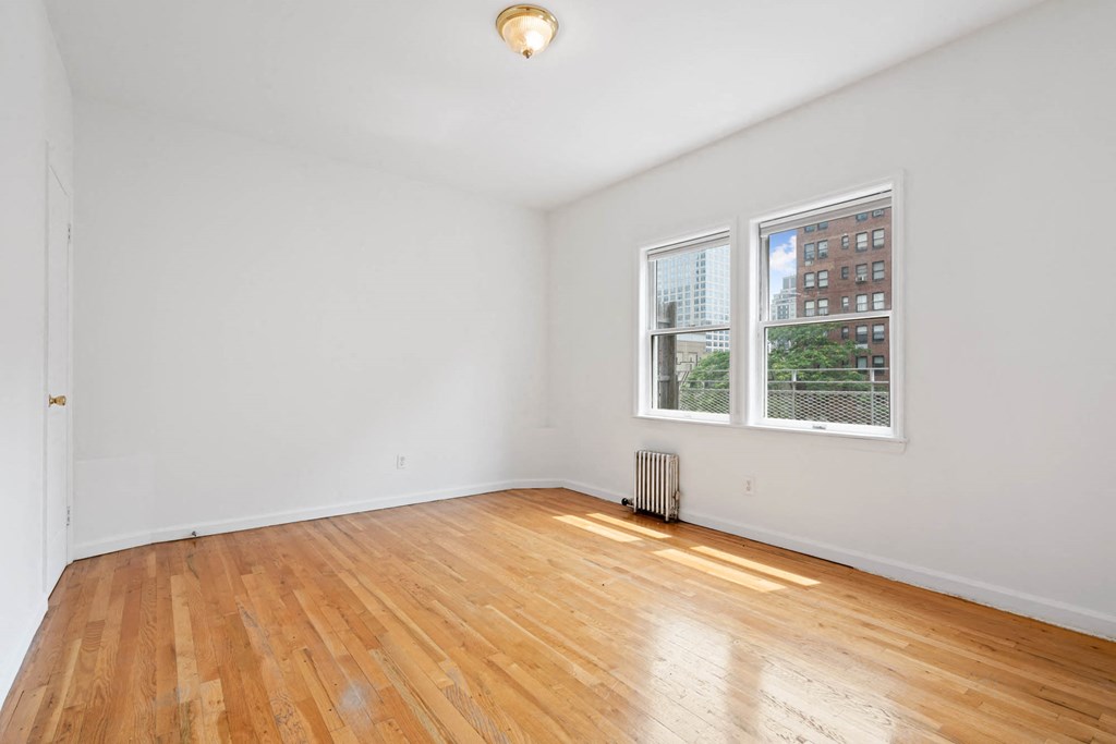 a living room with hardwood floors and two windows