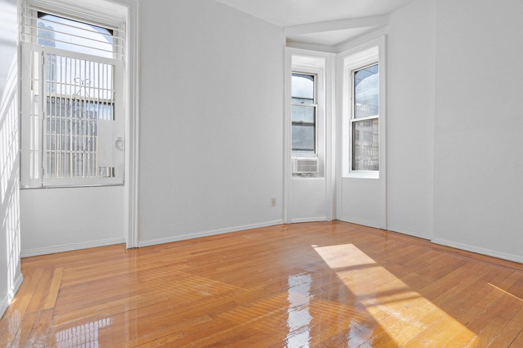 an empty living room with wood floors and white walls