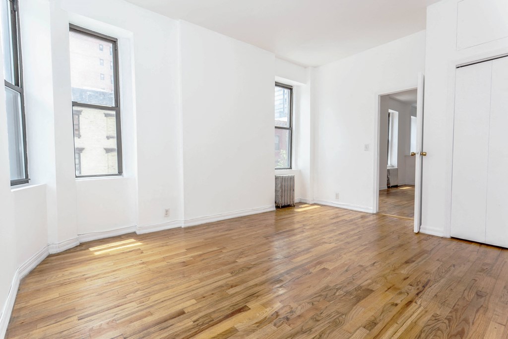 an empty living room with white walls and wood floors