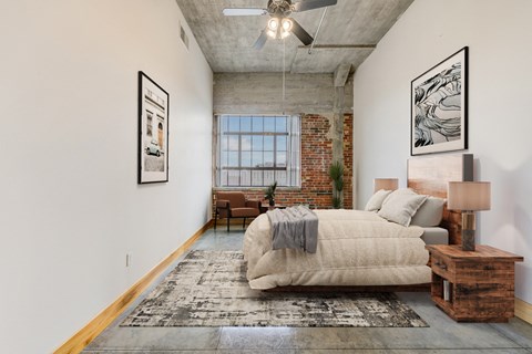 A bedroom with a large bed and a rug on the floor.