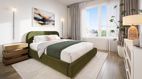 A bedroom with a green bed and a white nightstand.