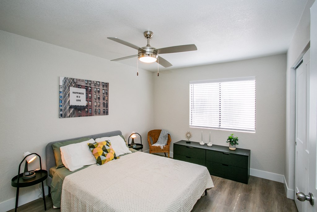 a bedroom with a bed and a ceiling fan